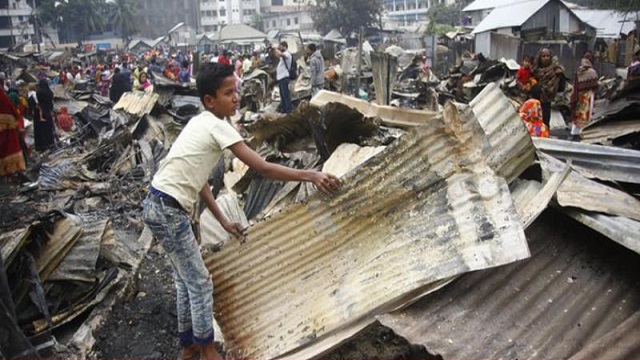 পুড়ে যাওয়া টিন সংগহ করছে এক কিশোর